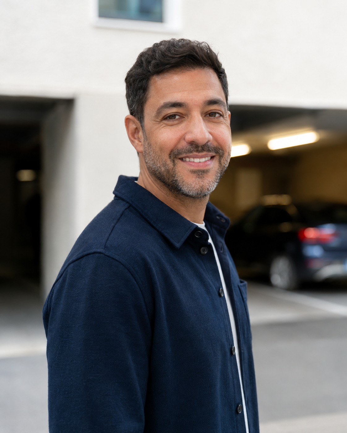Portrait de Karim devant l’entrée d’un parking couvert